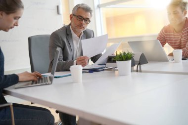 Öğretmen öğrencilere masa etrafında giving bol