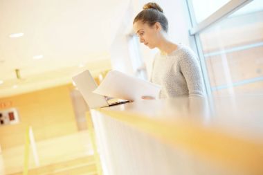 Öğrenci kız okul salonunda dizüstü bilgisayar ile bağlı