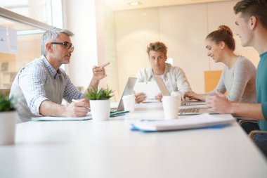 Öğretmen masa etrafında öğrenciler ile Toplantı 