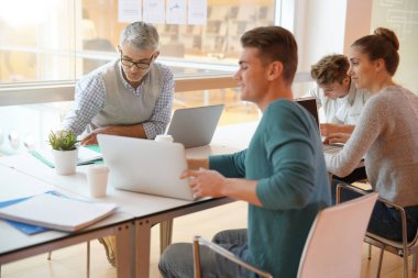 Öğretmen masa etrafında öğrenciler ile Toplantı 