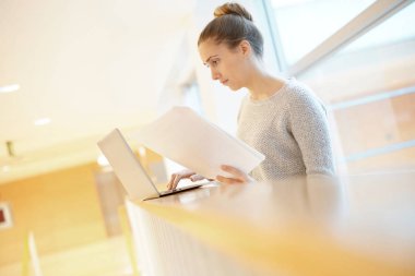 Öğrenci kız okul salonunda dizüstü bilgisayar ile bağlı