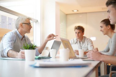 Öğretmen masa etrafında öğrenciler ile Toplantı 