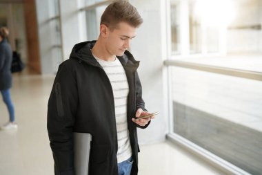 Öğrenci okul koridorunda smartphone kullanarak