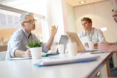 Öğretmen masa etrafında öğrenciler ile Toplantı 