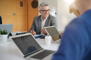 Öğretmen öğrencilerle masa etrafında çalışma