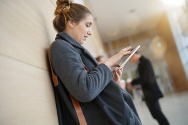 Kolej kız salonda ayakta tablet ile bağlı