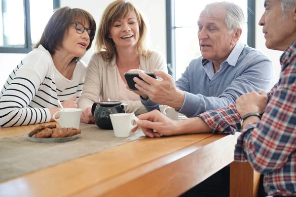 Skupina Senior Přátel Při Pohledu Obrázky Smartphone — Stock fotografie