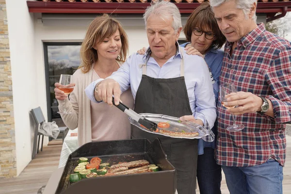 Groep Senior Mensen Voorbereiding Barbecue Lunch — Stockfoto