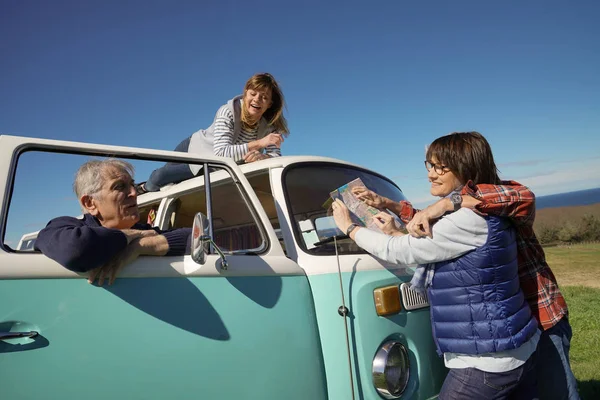 Senior people on a road trip with camper van reading map