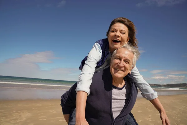 Homem Sênior Dando Passeio Piggyback Para Mulher Praia — Fotografia de Stock