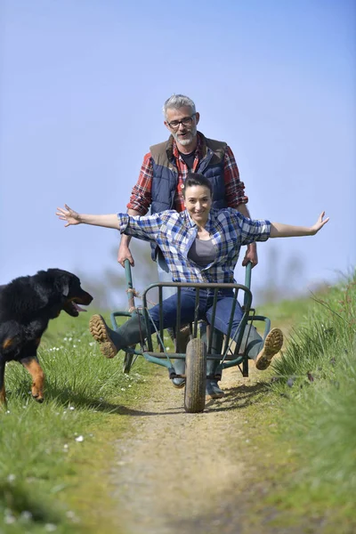 Agricoltore Spingendo Donna Carriola — Foto Stock