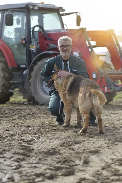 Bauer Streichelt Hund Vor Der Scheune Traktor Hintergrund — Stockfoto