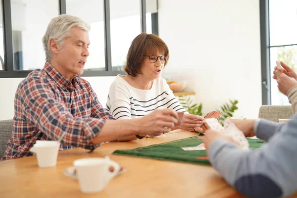 Amigos Seniores Casa Jogando Cartas — Fotografia de Stock