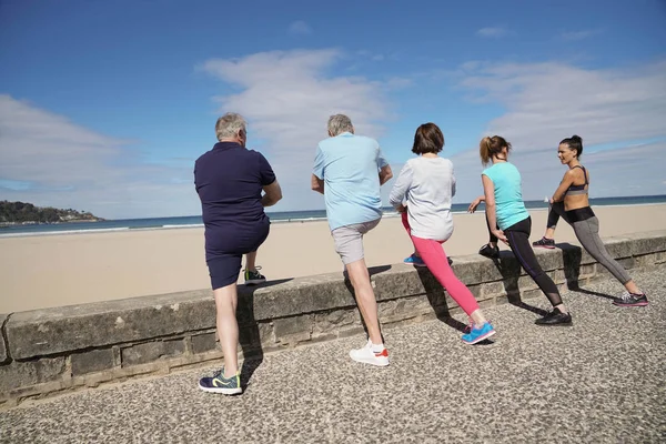 Grupp Ledande Personer Stretching Stranden Med Coach Flicka — Stockfoto