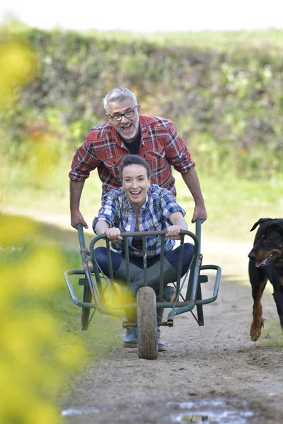 Bauer Schubst Frau Schubkarre — Stockfoto