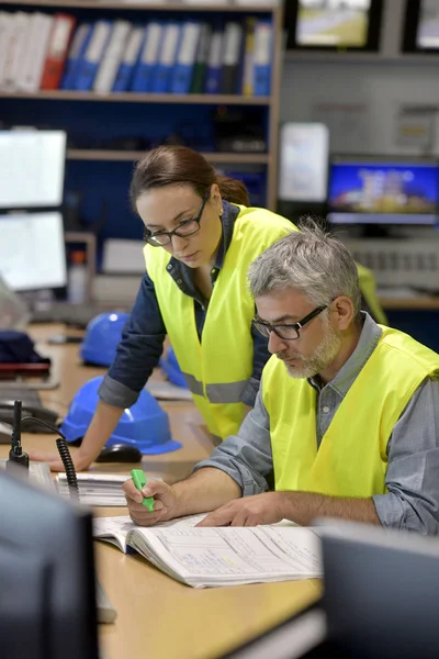 Technicians working in industrial plant control room