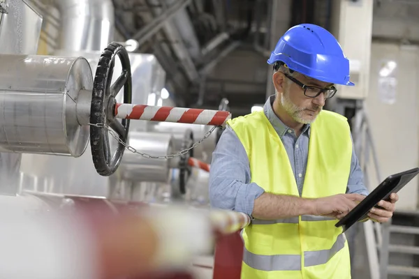 リサイクル工場にタブレットを接続している産業の技術者 — ストック写真