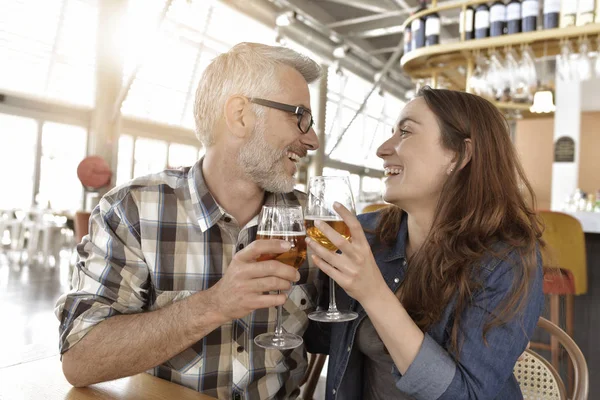夫妇在酒吧欢呼与玻璃啤酒 — 图库照片