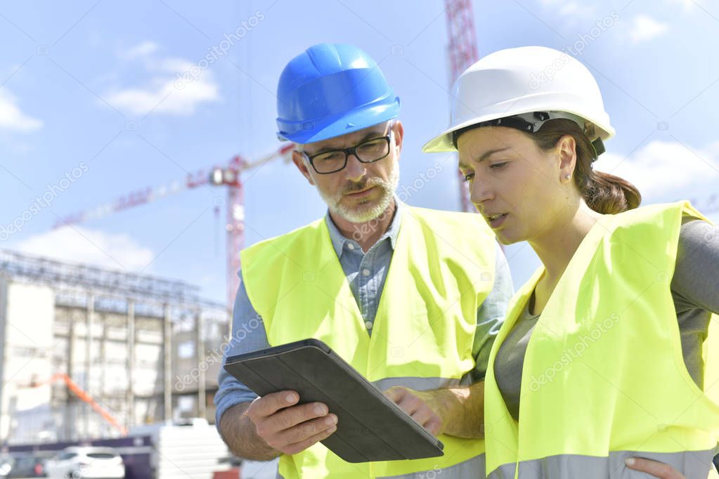 Construction manager and engineer working on building site