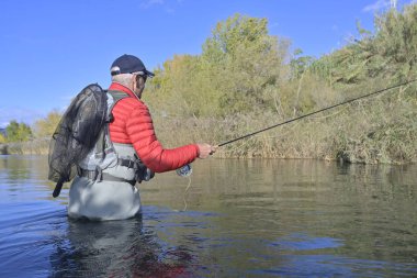 Sonbaharda ve hızlı nehirde uçan balıkçılar