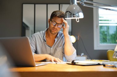 Ofiste dizüstü bilgisayarda çalışan orta yaşlı bir adam