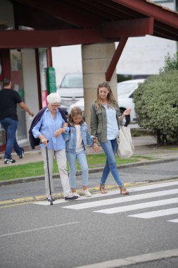 Büyükanne, anne ve kız karşıdan karşıya geçiyor.