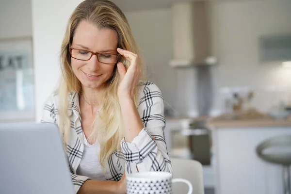 コンピューターの前で眼鏡をかけた若い女性が — ストック写真