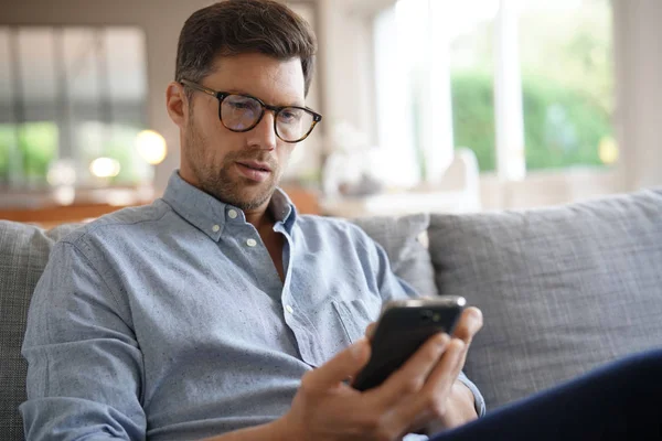 Lächelnder Mann Entspannt Sich Auf Sofa Telefoniert — Stockfoto