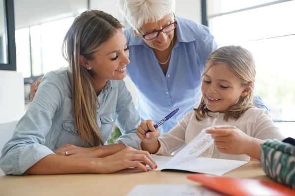 Liten Flicka Gör Läxor Mamma Och Mormor Tittar Henne — Stockfoto