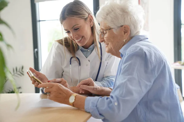 Mujer Anciana Con Enfermera Casa Mirando Tableta —  Fotos de Stock