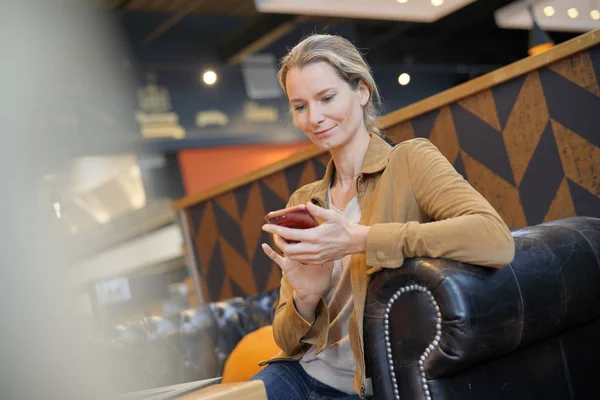 young businesswoman smiling on the phone in a cafeteria