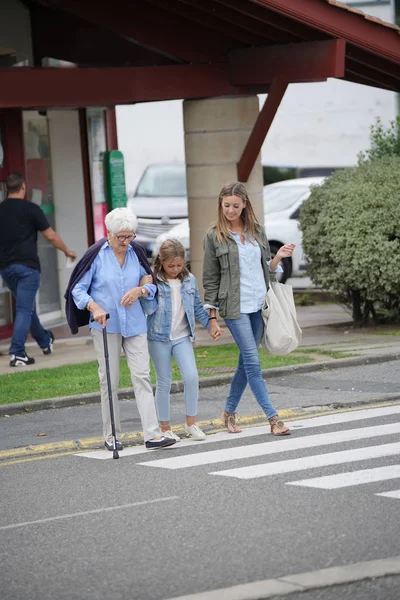 Grandmother, mother and daughter crossing the street