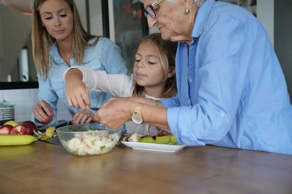 Gadis Kecil Dengan Ibu Dan Nenek Menyiapkan Salad Buah — Stok Foto