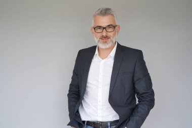 Gri arka planda duran iş adamının portresi