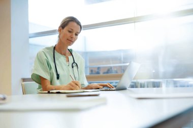Horspital 'daki hemşire dizüstü bilgisayarda çalışıyor.