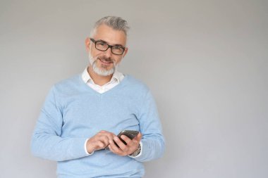 Akıllı telefon kullanan orta yaşlı bir adamın portresi. 