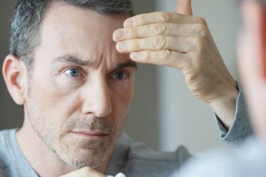 Yüzüne makyaj yapan bir adamın portresi.