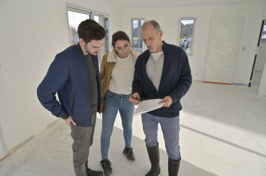 Genç çift inşaat halindeki evi ziyaret ediyor.