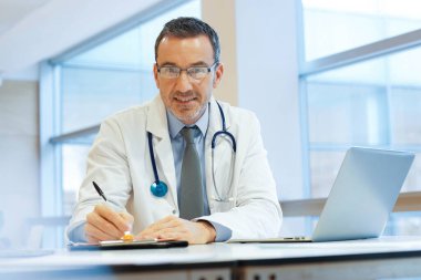 Hastanedeki doktor dizüstü bilgisayarla çalışıyor.