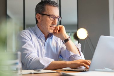 İşletme müdürü laptopta çalışıyor.