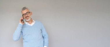 Akıllı telefon kullanan orta yaşlı bir adamın portresi.