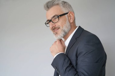 Gri arka planda duran iş adamının portresi