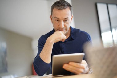 Dijital tablete bağlanmış orta yaşlı bir adamın portresi