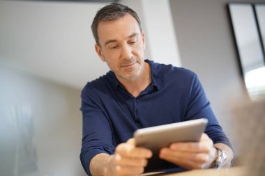 Dijital tablete bağlanmış orta yaşlı bir adamın portresi