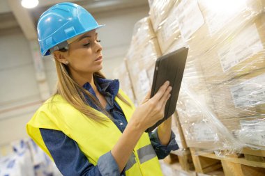 Depo kadın yöneticisi gelen malları kontrol ediyor