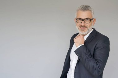 Gri arka planda duran iş adamının portresi