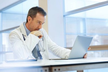 Hastanedeki doktor dizüstü bilgisayarla çalışıyor.