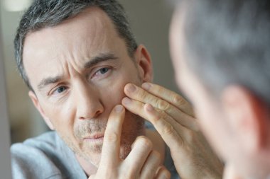 Aynanın önünde insan portresi, cilt bakımı