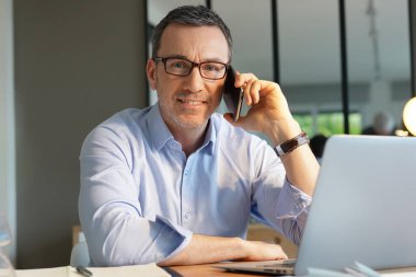 Ofiste çalışan bir işletmeci telefonda konuşuyor.
