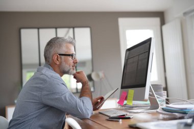 Dijital tabletle çalışan olgun bir adam